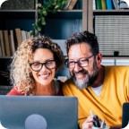 Couple look at laptop together.